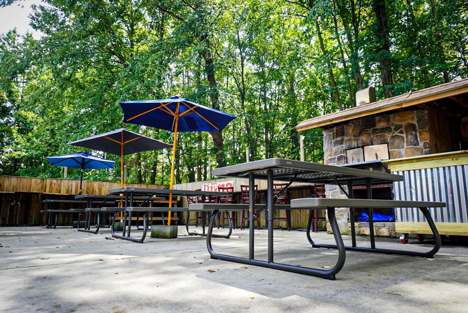 The sunny outdoor patio at Tavern in the Quarters, with picnic tables and colorful umbrellas